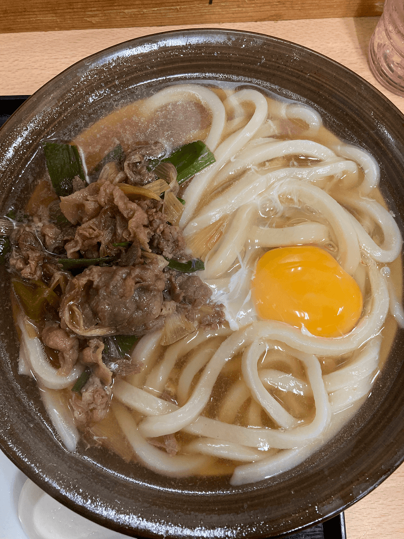 牧のうどんの肉うどんに生卵トッピング