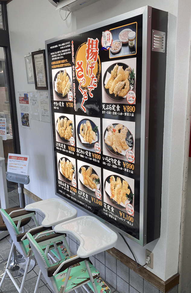 天ぷらひらおのメニュー看板と子供用椅子